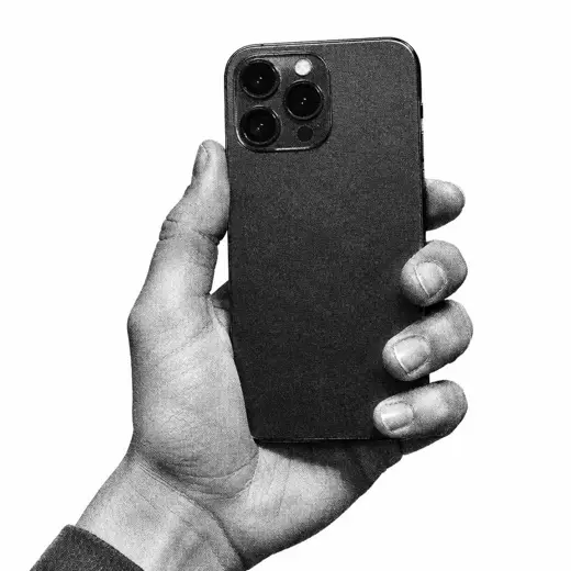Črno-bela roka drži pametni telefon, vidne so zadnje kamere
